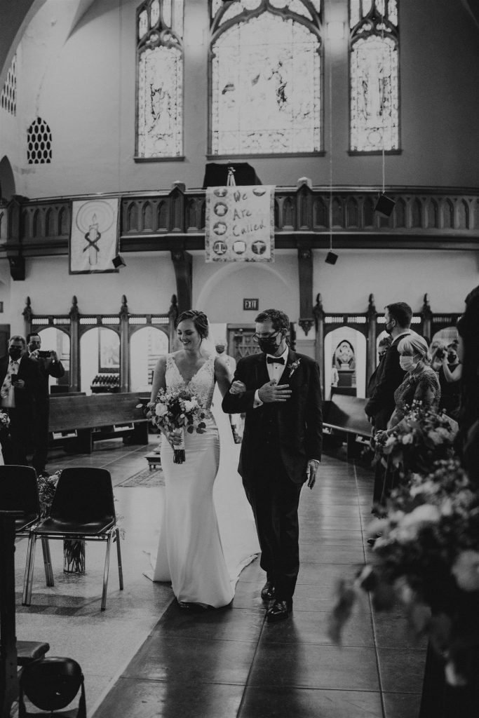 Bride walking down the aisle with her father during wedding ceremony in a Catholic church in Portland, Oregon