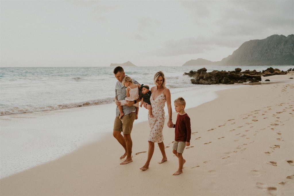 Family walking down the beach in Hawaii during their photoshoot outdoors.