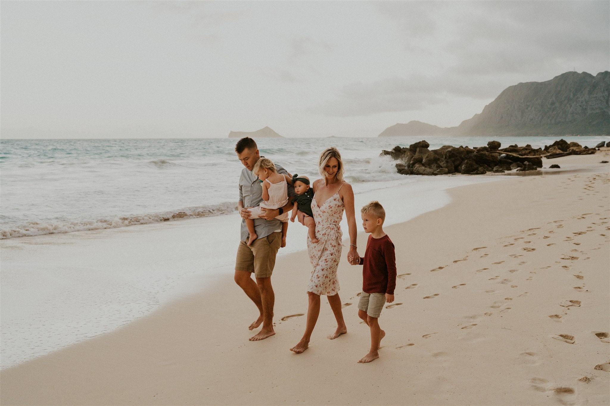 Family walking down the beach during a photoshoot